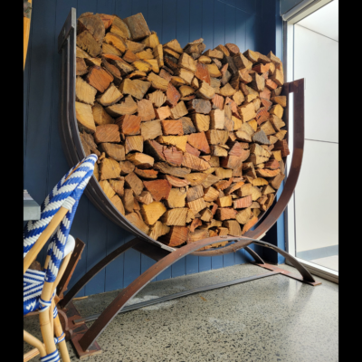 Steel U-shaped log rack filled with chopped fire wood.